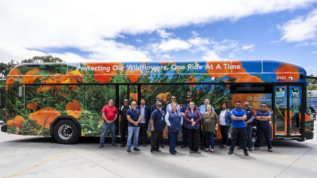 Employees standing in front of One Ride at a Time bus